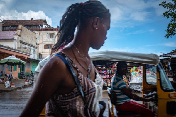 Photographies de Madascar. Diego-Suarez sous la pluie, jeune fille passante au premeir plan.