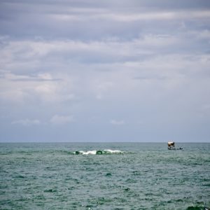 Photographie de Madagascar. Océan Indien à Manakara. Petit boutre et vague.