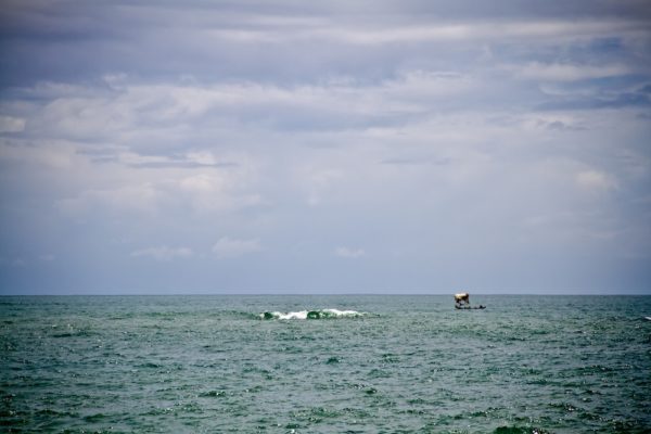 Photographie de Madagascar. Océan Indien à Manakara. Petit boutre et vague.