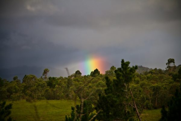 Photographie de Madagascar. Vue depuis le taxi-brousse. Arc-en-ciel tronqué dans la montagne.